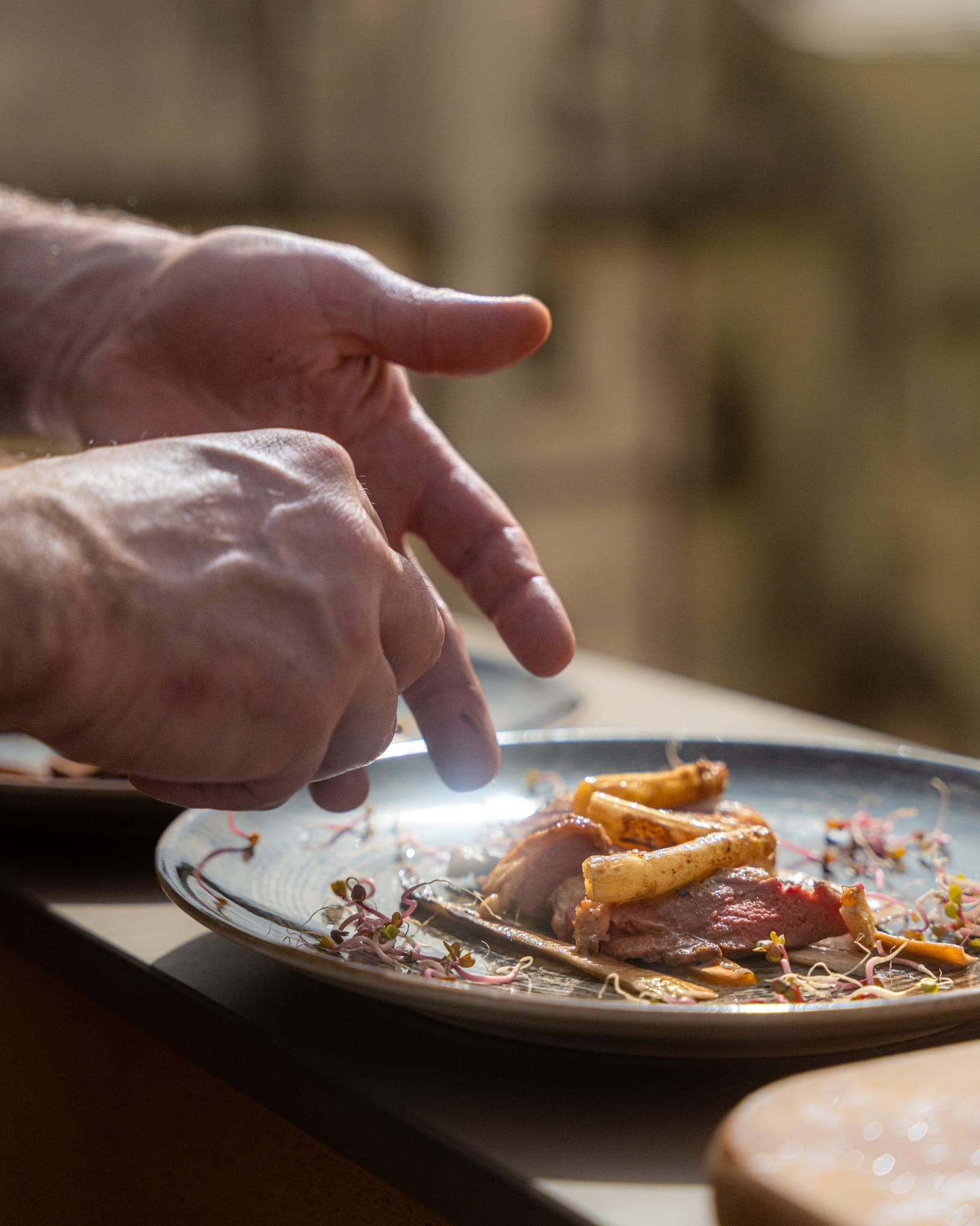 Lo chef impiatta l'anatra guarnendola con germogli